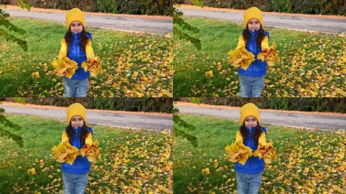 美丽的欧洲孩子，一个可爱的小女孩递给相机两束落叶的干花束