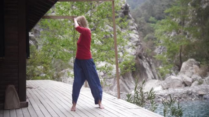 湖边的瑜伽-精神振奋的女人闭着眼睛在现场摇摆
