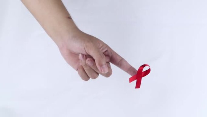 带有红丝带的手符号表示对白色背景上孤立的HIV aids患者的关注