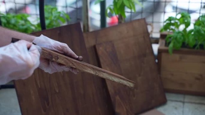 在木板修复过程中，木匠在手套上用保护色涂料染色木材表面，使用海绵进行抛光。木匠用油性漆涂覆木材，以防