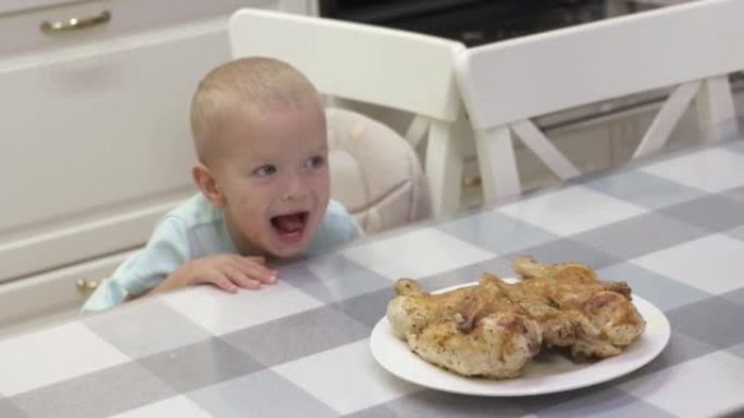 快乐的孩子微笑着看着家里餐桌上的整只烤鸡。