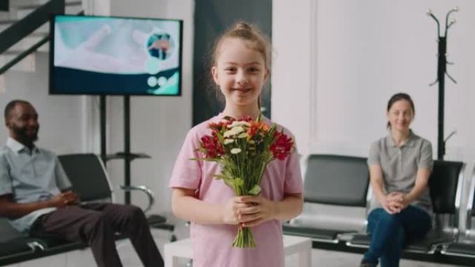 微笑的小女孩在医院候诊区捧着花束