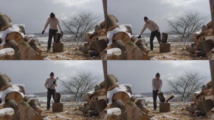穿着肮脏衣服的男人拉直原木对着相机和砍woo