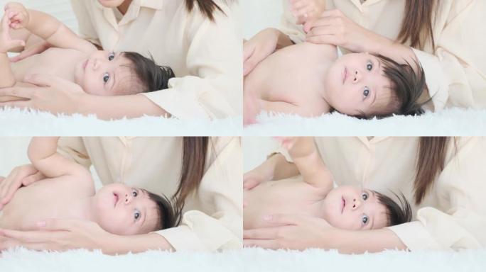 小女孩洗澡后躺在布上给妈妈撒婴儿爽身粉。