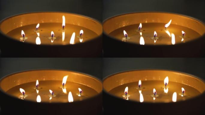 带有几个灯芯的大型点燃蜡烛的特写视图