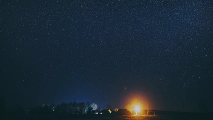 4k延时夜星空村庄上方。乡村景观上的自然天空背景。流星穿越深蓝色的天空。大曝光。延时，延时，延时