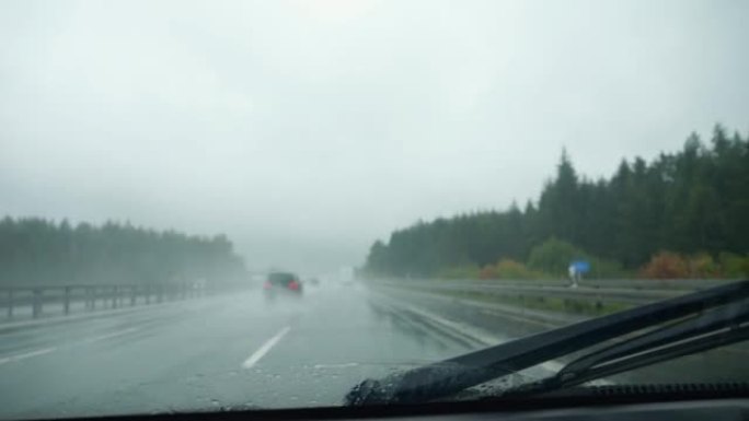 雨中的高速公路，汽车驾驶舱的视野，雨刮器从挡风玻璃上收集水。