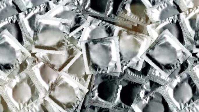 银色包装的避孕套在视频中循环播放，有轻微的散景效果。