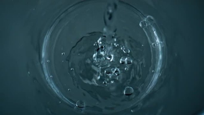 纯净水填充玻璃俯视图特写。水晶透明液流鼓泡