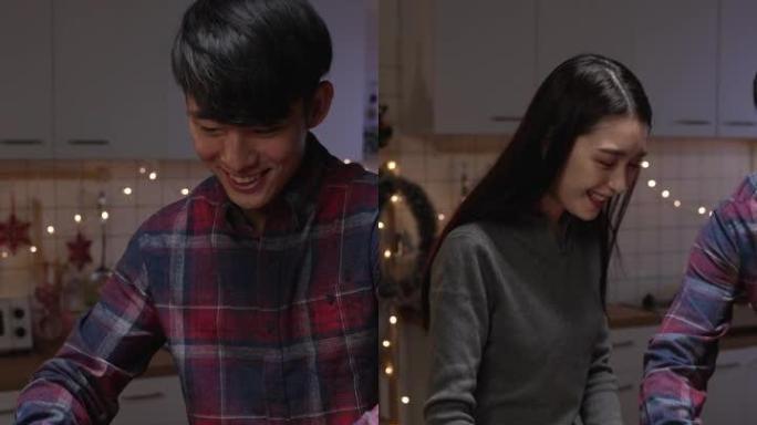 垂直屏幕: 亚洲韩国男性拿着美味的火鸡从厨房走到餐厅吃圣诞晚餐。男人在挨饿的女友时把鸡肉放在盘子上