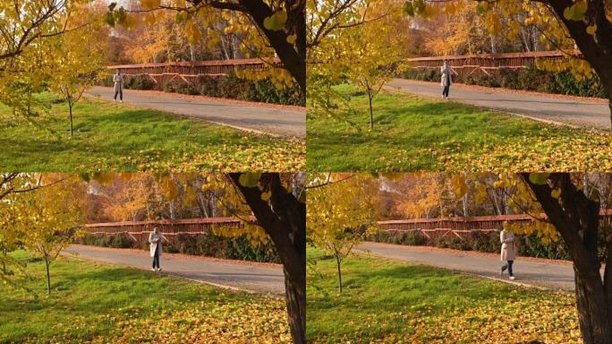 在一个秋日阳光明媚的日子里，一个穿着米色毛呢大衣的漂亮女人走在满是落叶的街道上