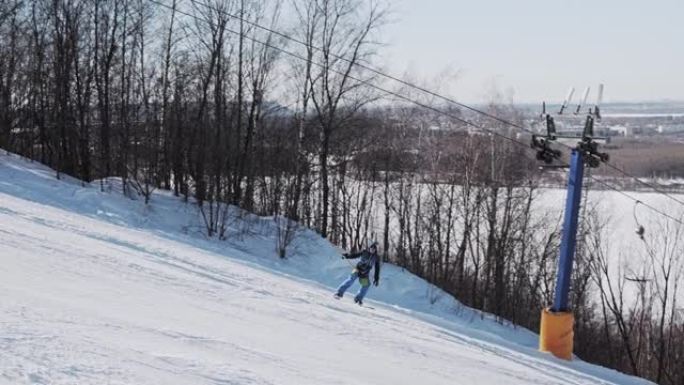 单板滑雪者使用T型杆升降机攀爬，并制作了黄油尾巴抓住技巧