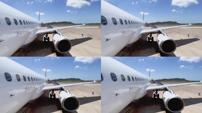 从停在伊比沙岛巴利阿里岛机场的飞机的机身机翼和发动机的前门平移，晴天连接楼梯。西班牙
