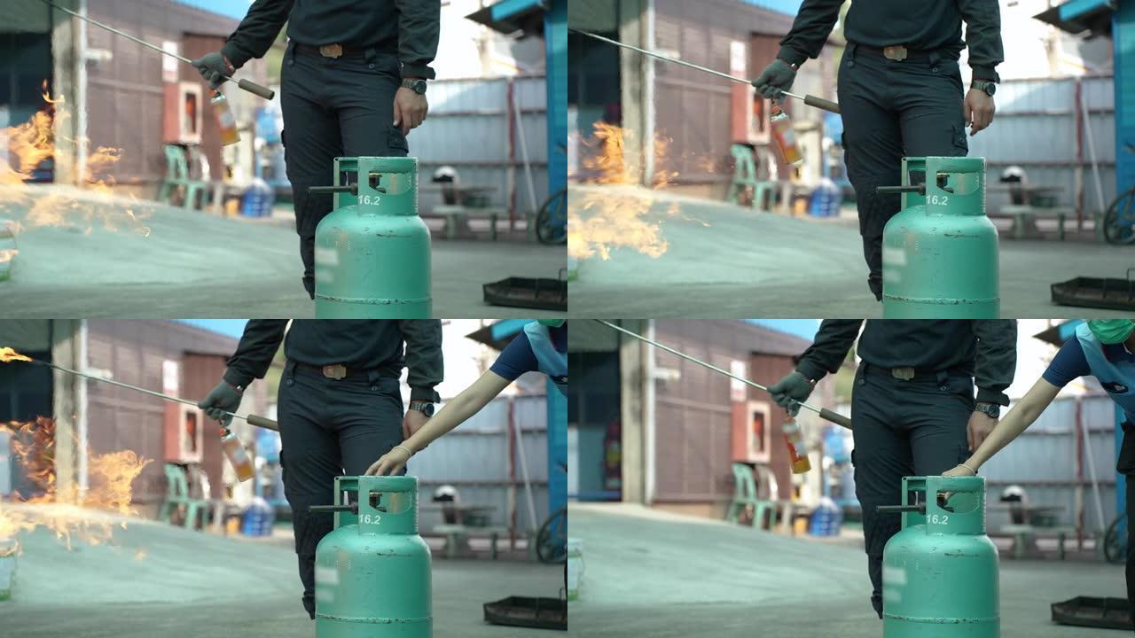 男子教或训练如何关闭灭火器以扑灭液化石油气烹饪气罐中的火。