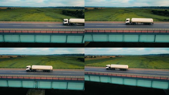 带汽油箱拖车的货车在公路上通过桥梁行驶并运送货物