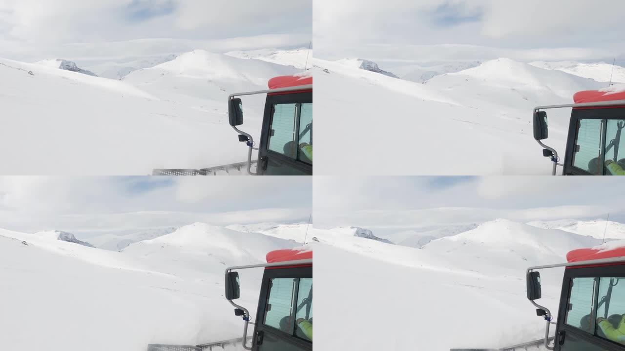 雪猫ratrack用扫雪机准备滑雪场，驶过滑雪胜地的深雪道。重型机械运输山峰上的自由式滑雪者