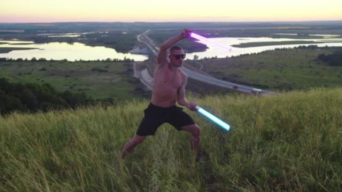 一个戴着太阳镜的肌肉发达的人在田野里挥舞着两个霓虹灯