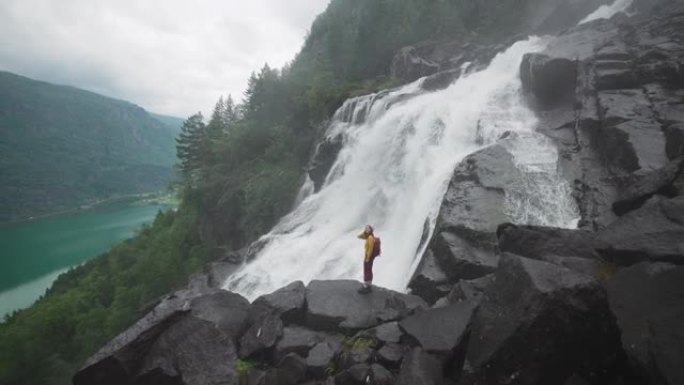 挪威山区瀑布附近的女人徒步旅行