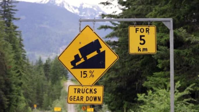 陡峭的山坡下降在加拿大不列颠哥伦比亚省99号高速公路上使用低档交通标志