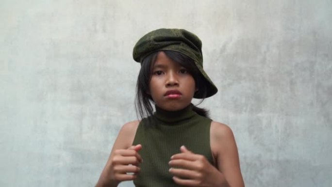 亚洲十几岁的潮女孩摆砸拳头的病毒视频在白色旧墙的背景