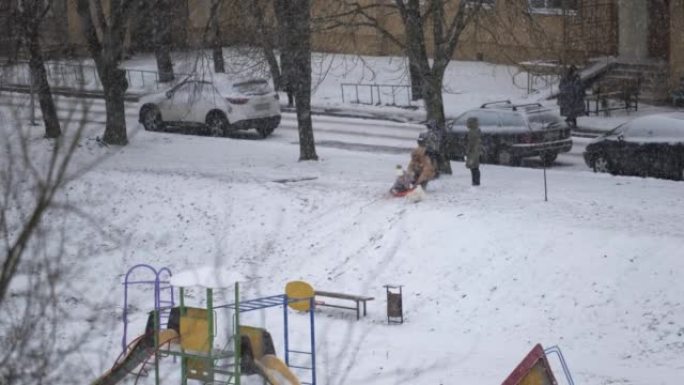 降雪期间一家人在院子里散步