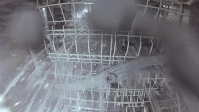 主人修理洗碗机，并检查喷嘴机构的运行情况，该机构旋转并喷水。洗碗机内的数码相机。洗碗机的内部视图。