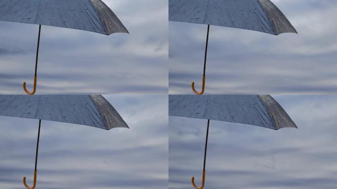 一只漂浮在天空中的黑色雨伞。孤立的雨伞，带有讲台，可在季风的背景下放置产品。复制文本和广告的空间。季