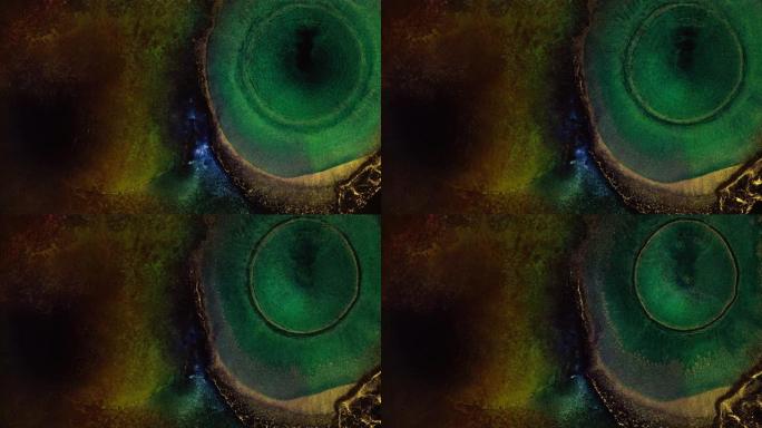金属金色和绿色液体墨水宏。抽象爆炸光图案背景。化学反应液体油漆飞溅
