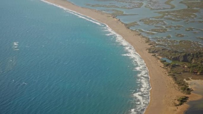 在土耳其美丽的沙滩空旷的海滩Iztuzu，阳光明媚的夏日风日，空中慢动作用海浪挥舞着大海。
