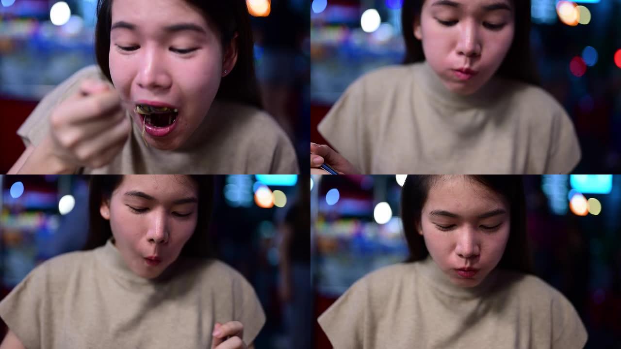 年轻女子在街头食品市场享受假期，在泰国曼谷的中国城市场上快乐的女人在吃食物，有街头食品概念的人
