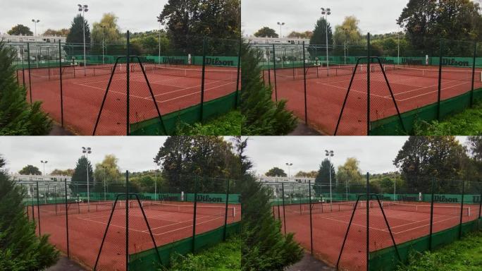 带有橙色粘土的网球场。黄昏时在新鲜空气中的私人庄园的网球场
