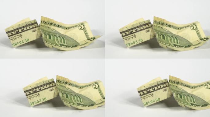 美元钞票的详细宏观纹理的幻灯片。白色背景上损坏的钞票的慢速美元拍摄。法定货币概念。撕裂和皱巴巴的钞票