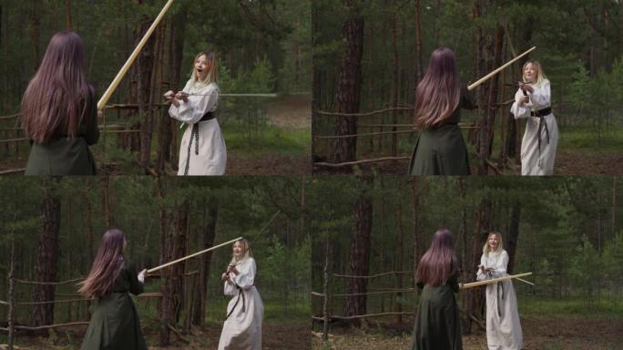 穿着优雅衣服的少女在营地用剑打架