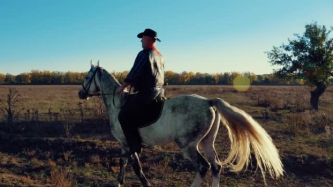 穿着牛仔装的男人在乡间小路上骑着白马骑马