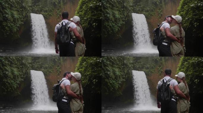 男女夫妇在印度尼西亚巴厘岛巴图尔山的隐藏瀑布接吻