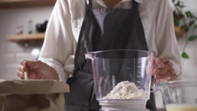 在厨房秤上称量面粉的过程，制作面团的正确配方厨具