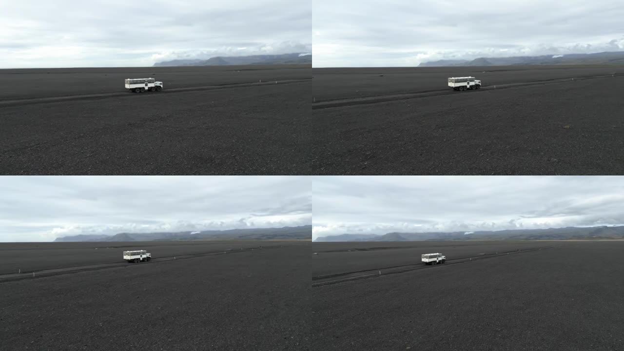 在冰岛，一辆越野改装的公共汽车快速驶出道路的侧面拍摄，鸟瞰图