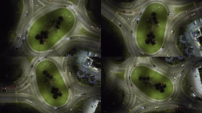 夜间带有镜头照明弹的环形交叉路口的上升旋转无人机视图 (2)