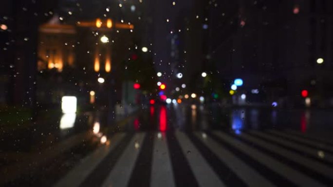 夜间市区下雨天交通散焦，车灯