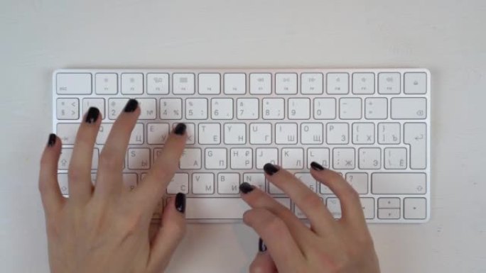 一个小女孩正在无线键盘上打字。女孩的手合起来了。从以上观点。4 k