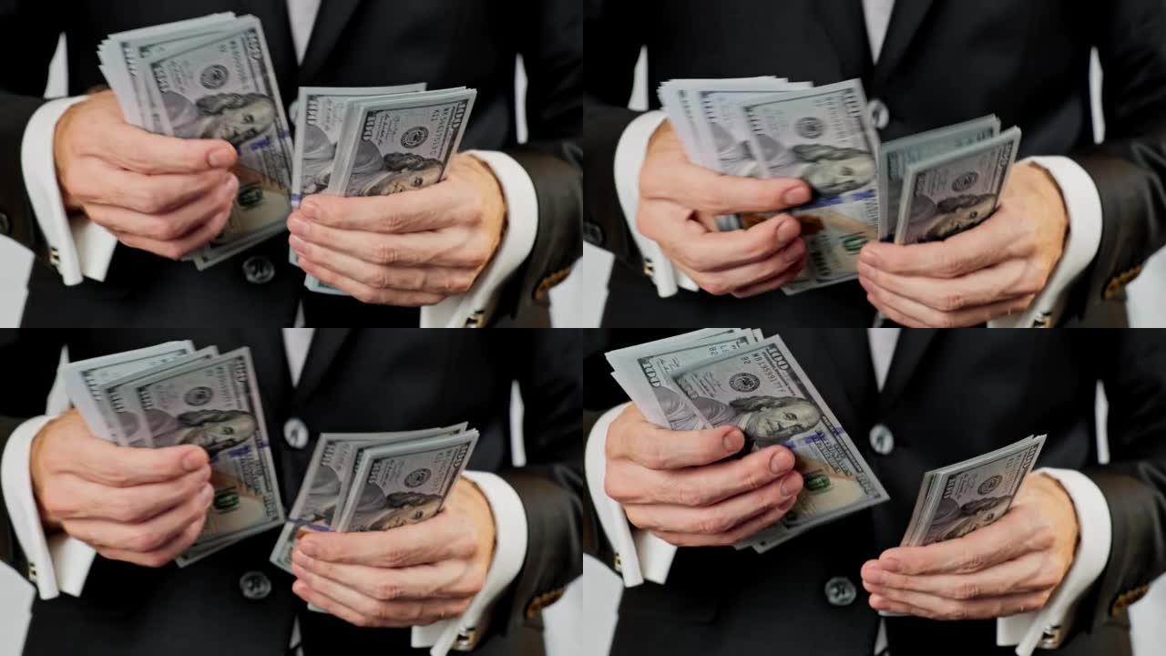 男性计算许多美国100美元的钞票。成功的商人