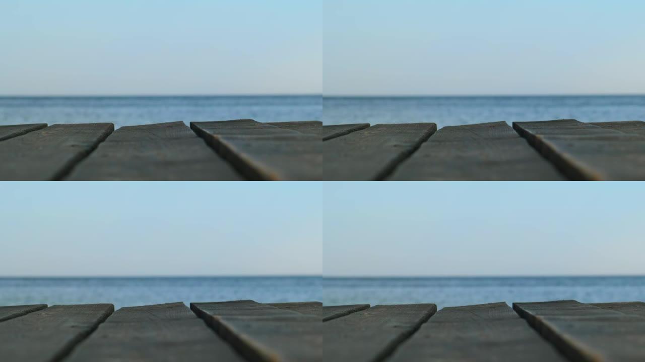 一个古老的木制码头，在模糊的蓝色海洋和天空的背景下特写镜头。全景横幅-复制空间。