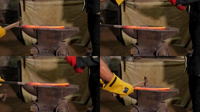 两个铁匠正在铁匠铺里用铁锤敲打铁砧上的热金属。