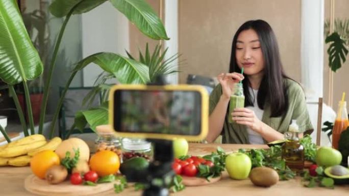 亚洲女性使用手机制作健康食品，为社交媒体制作视频内容