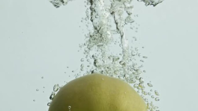青苹果落水特写。美味的季节水果流动透明液体