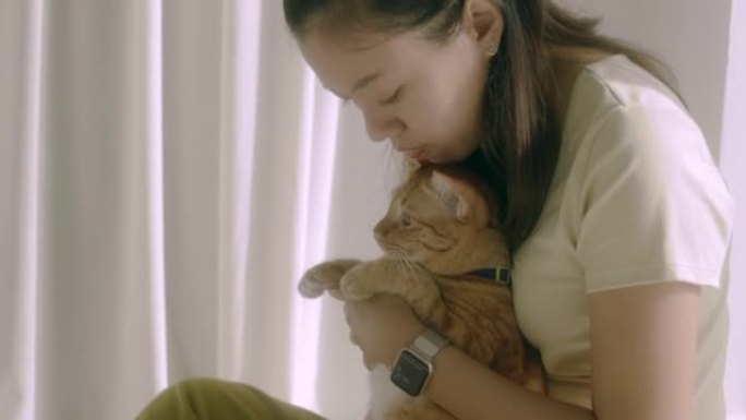 亚洲女人在新家玩虎斑猫。收养流浪猫的概念有一个爱并能照顾他们的新主人。