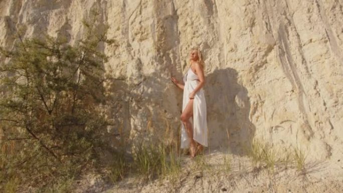 一个金发女孩正在采石场晒日光浴