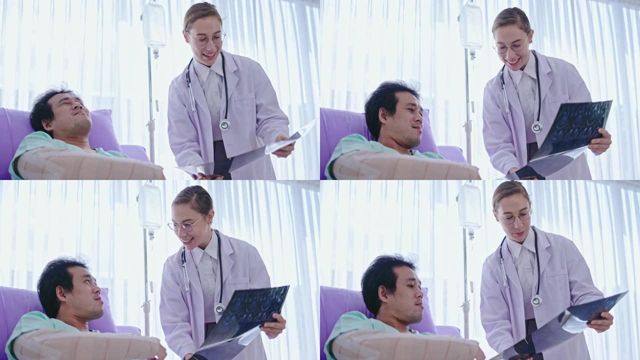 高加索女医生向在医院病床上听的亚洲男性患者解释脑部x光片。由专家医生护理。神经退行性疾病的诊断脑部血