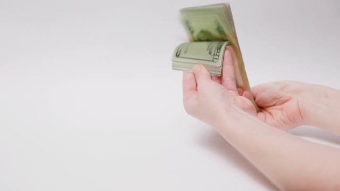女性双手握着一叠纸美元钞票，并显示金钱。投资和腐败的概念