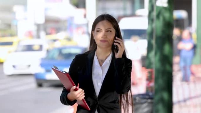 一位年轻的职业女性穿着商务服装，在市中心拿着一个档案
